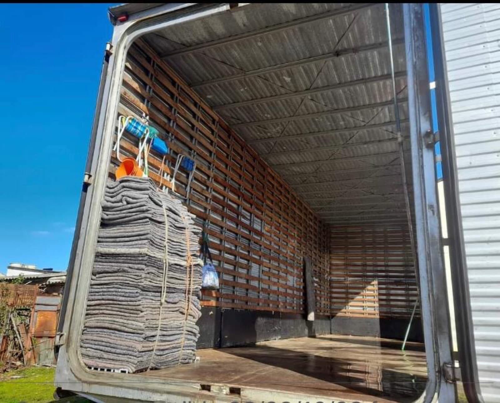 Interior de la caja del camión, con una pila de mantas de embalaje
