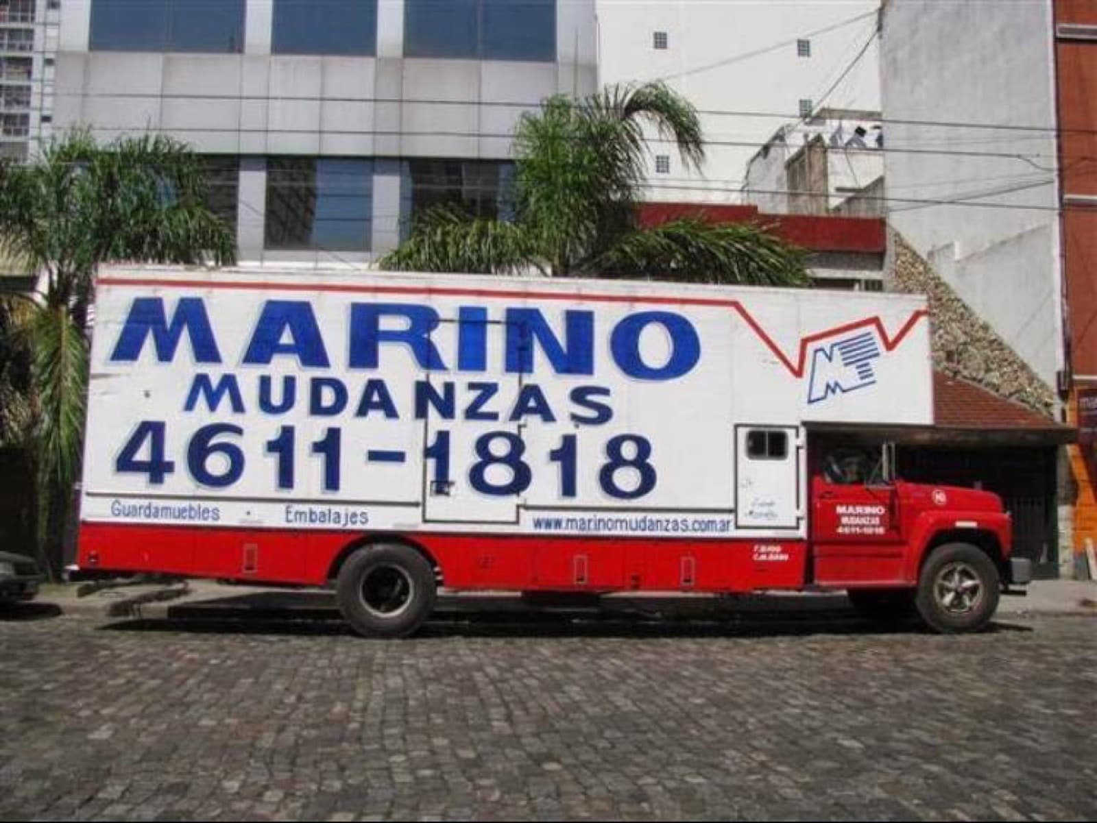 Camión blanco y rojo de Marino Mudanzas, de costado, con el teléfono 4611-1818