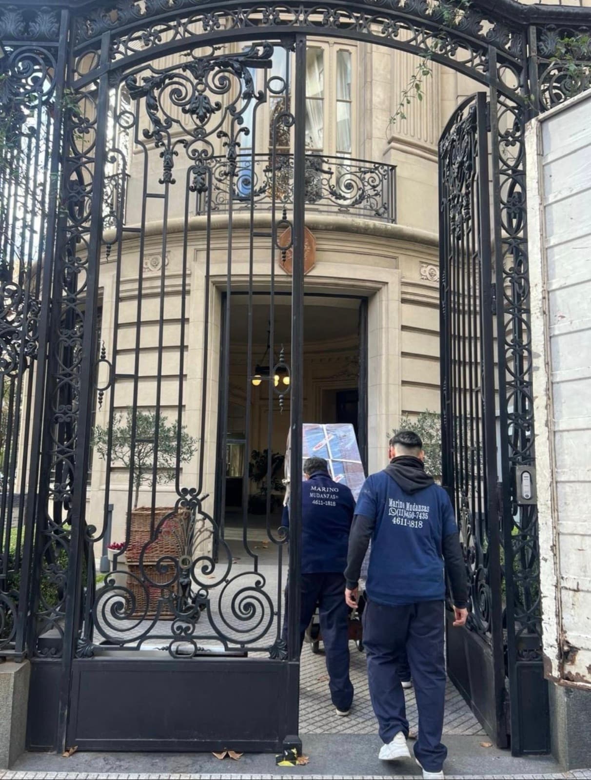 Dos operarios de Marino Mudanzas entrando a un edificio con una pieza embalada