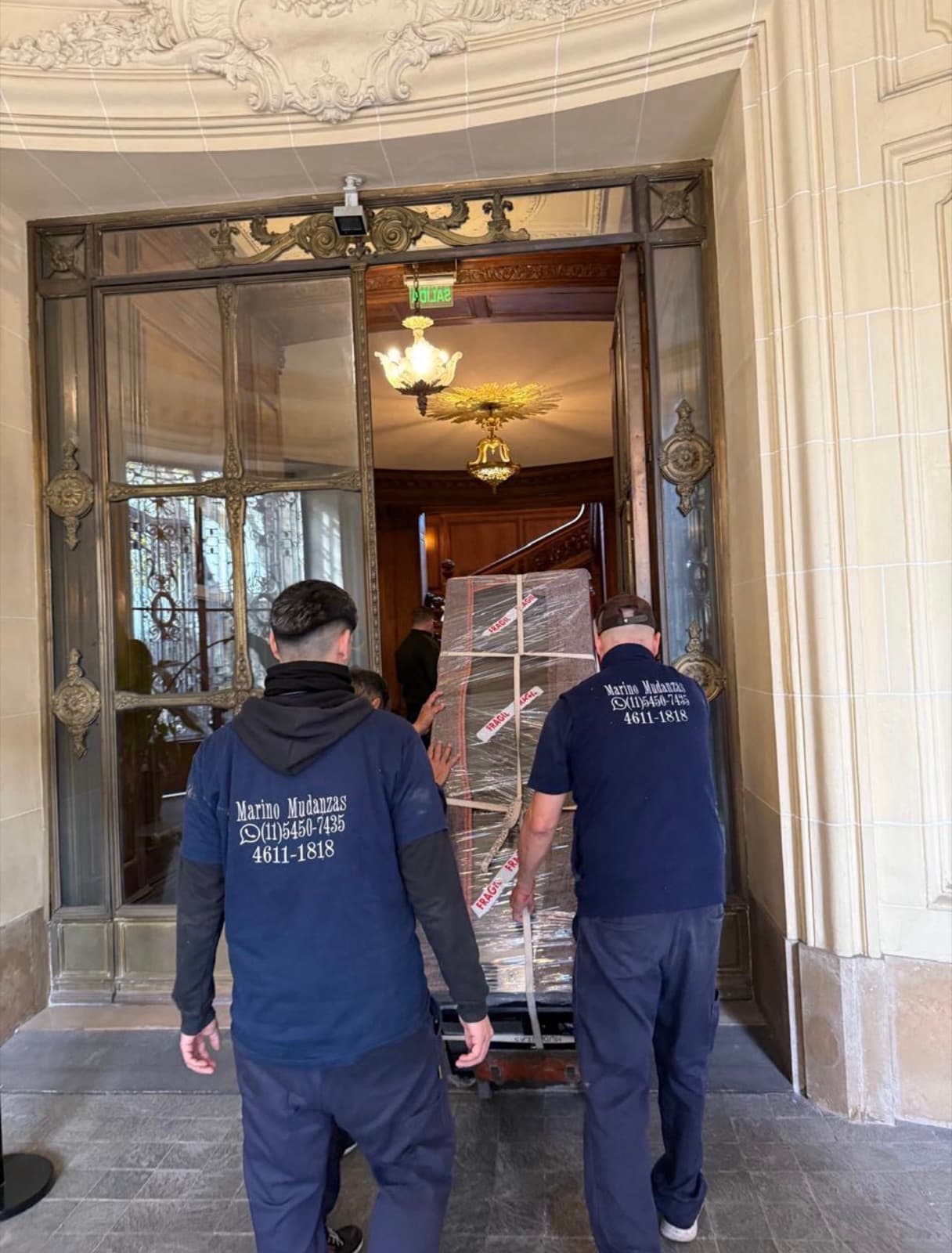 Operarios de Marino Mudanzas ingresando una pieza embalada y marcada como frágil